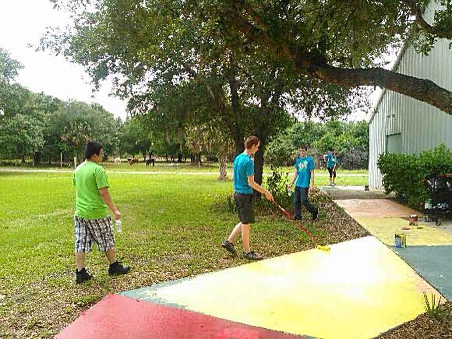 Kid painting the walkway different colors