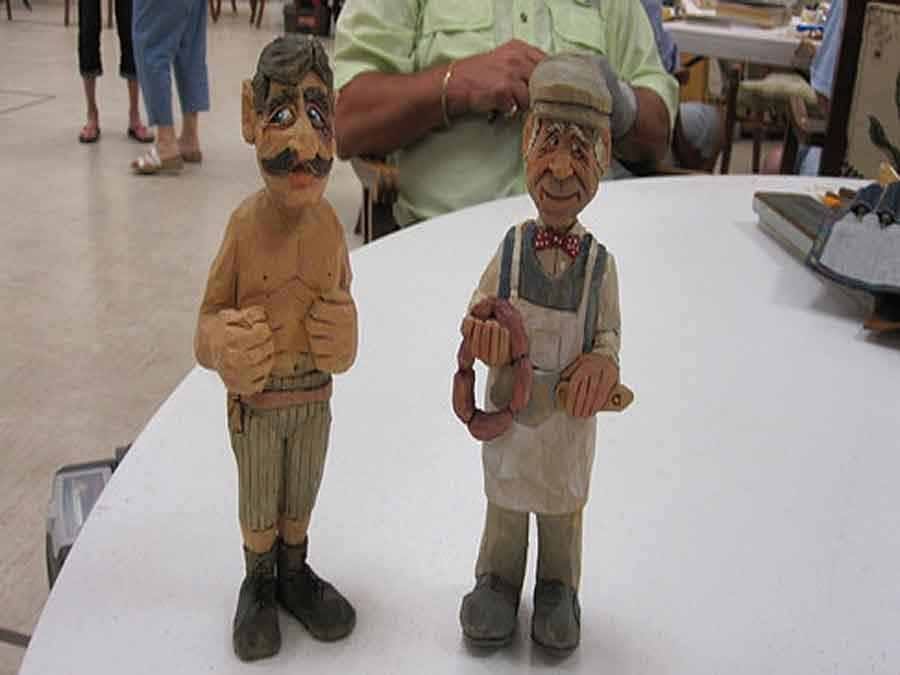 Two wood carvings of men by members