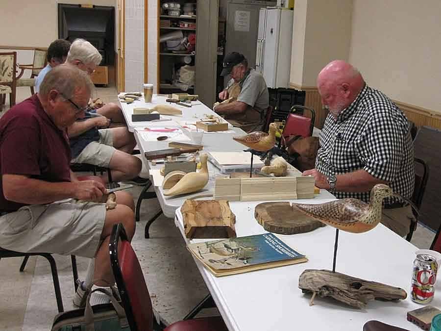 Club members working on carvings at table