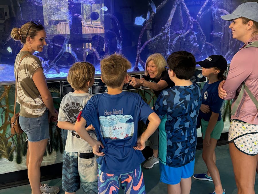 volunteer explaining an exhibit to family volunteer explaining an exhibit to family