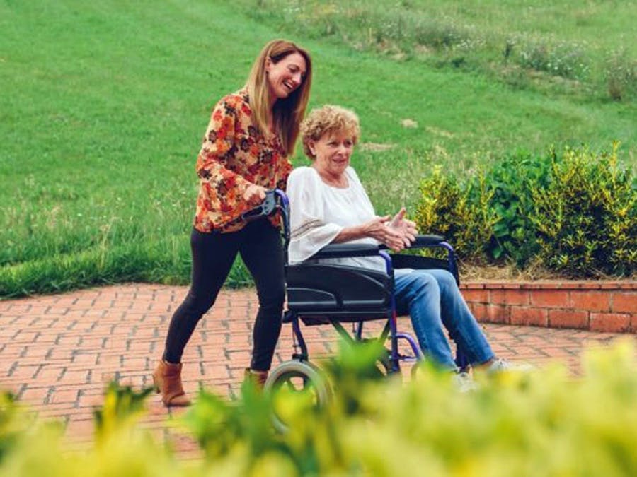 Woman pushing another in wheelchair