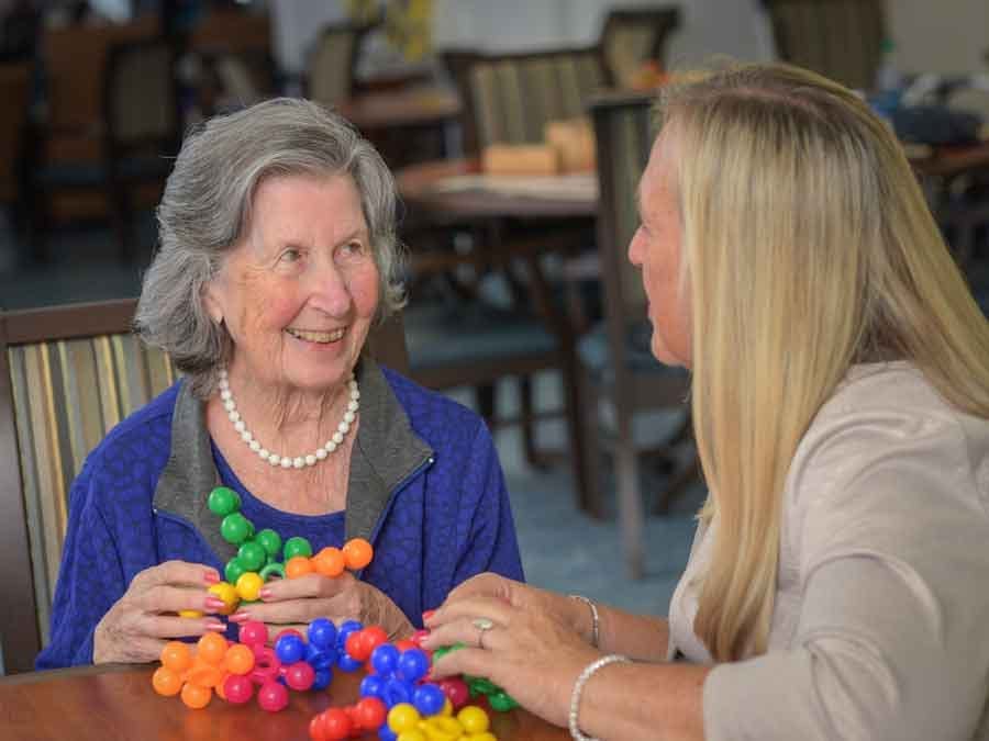 Senior woman talking to staff while playing a game