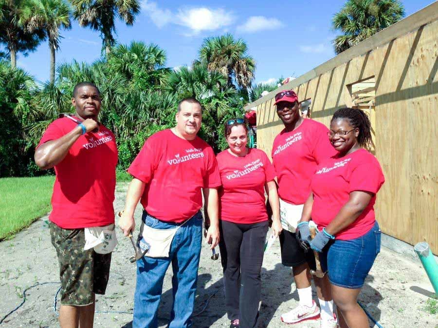 Volunteers posing in front of house built for Habitat for Humanity