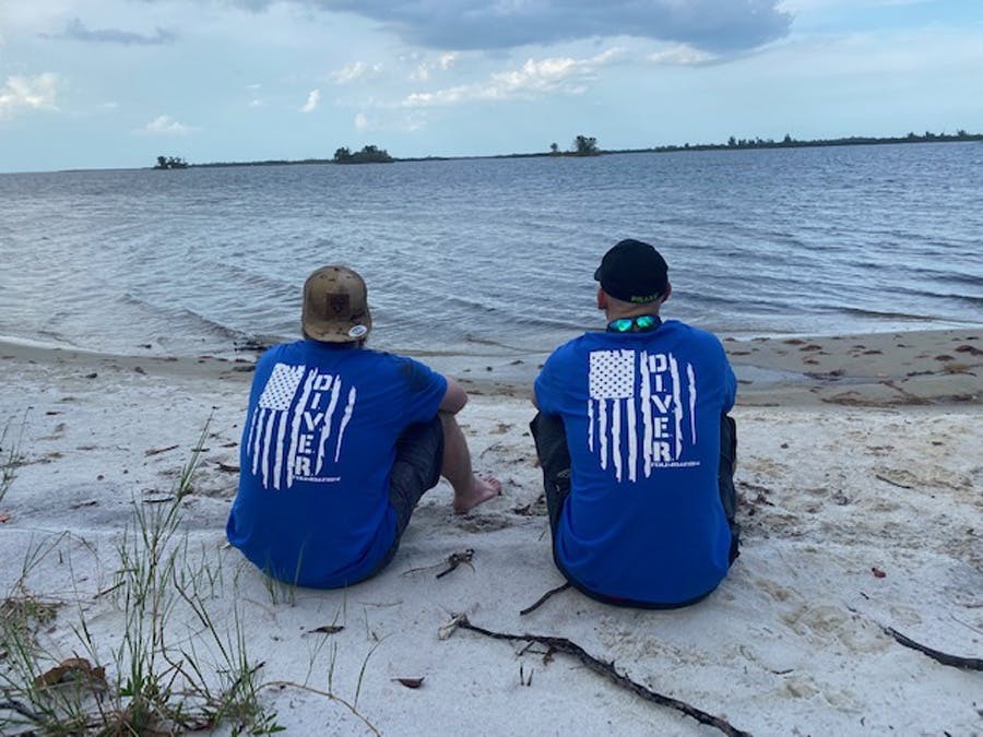 volunteers sitting on rivers edge
