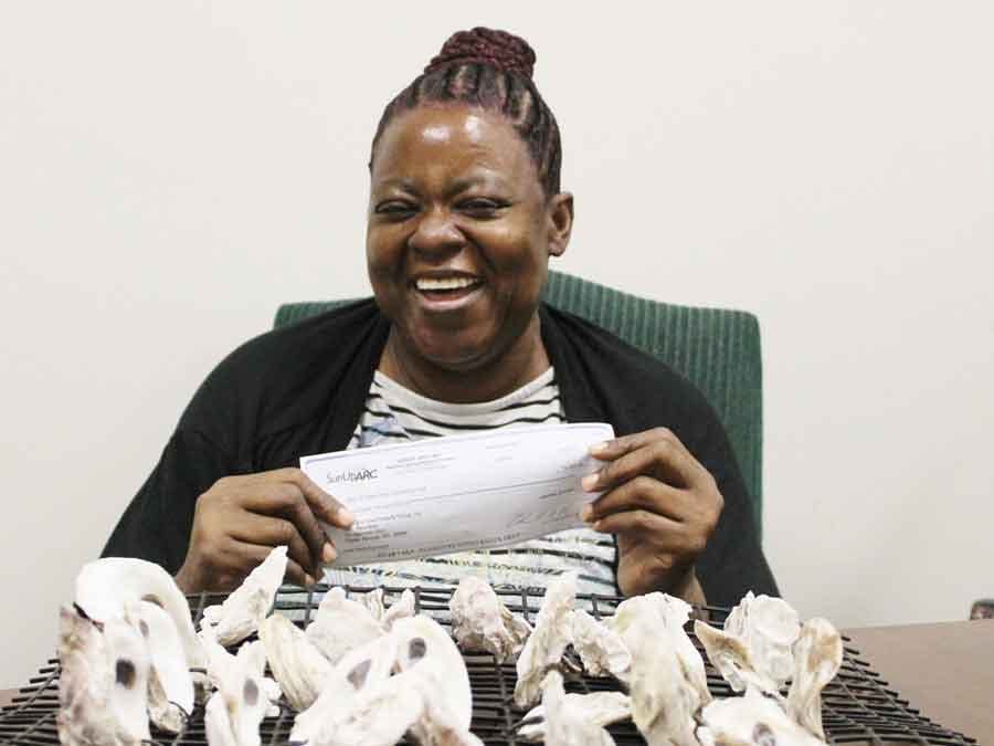 woman holding check and laughing