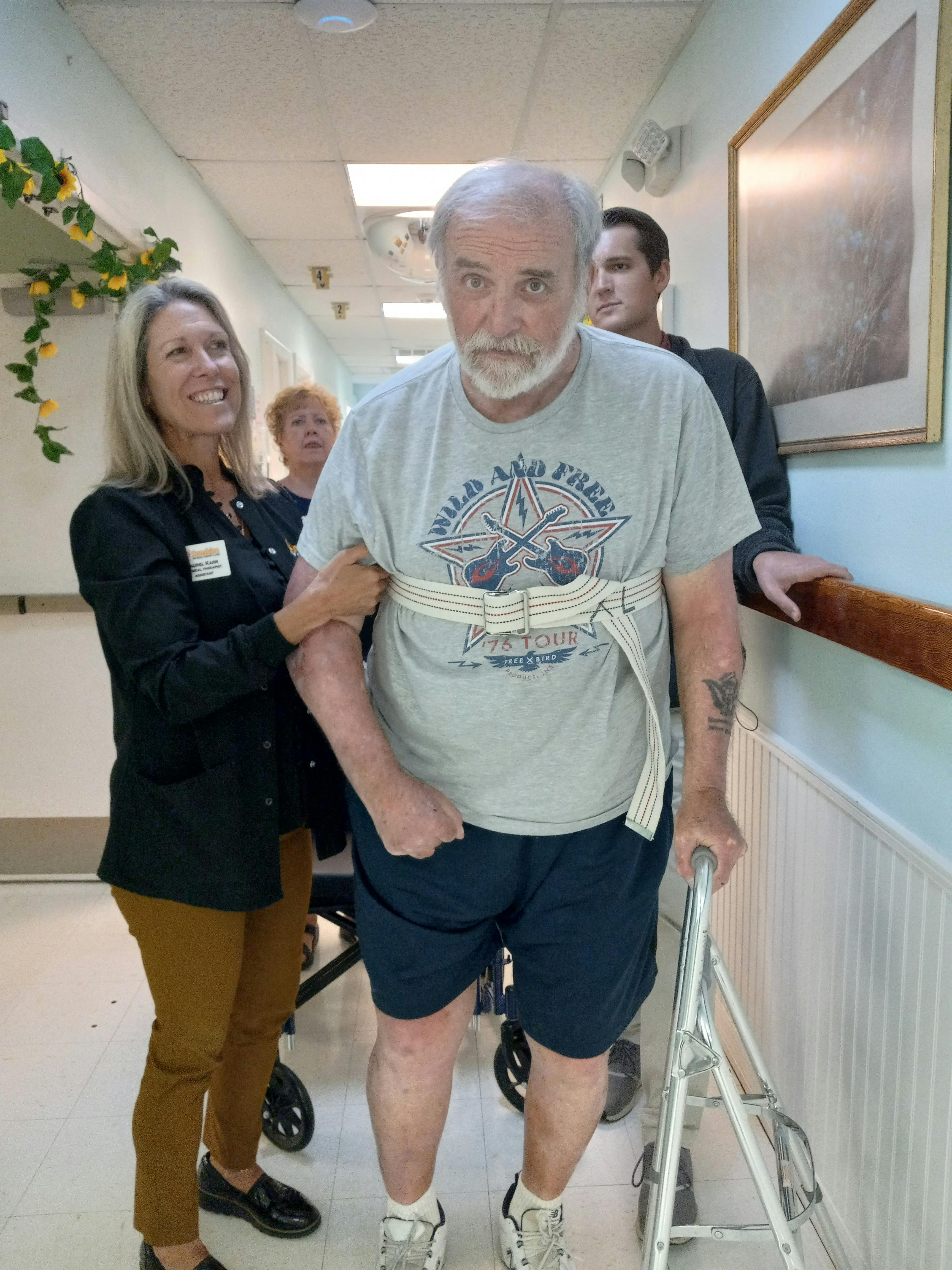 Therapist helping a gentleman walk