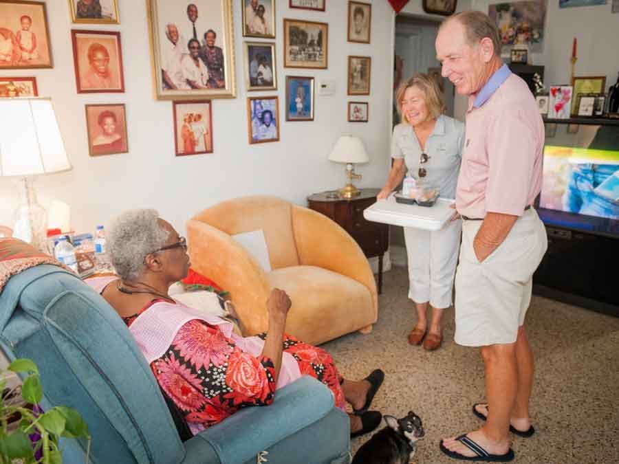 volunteers delivering food to elderly lady at home
