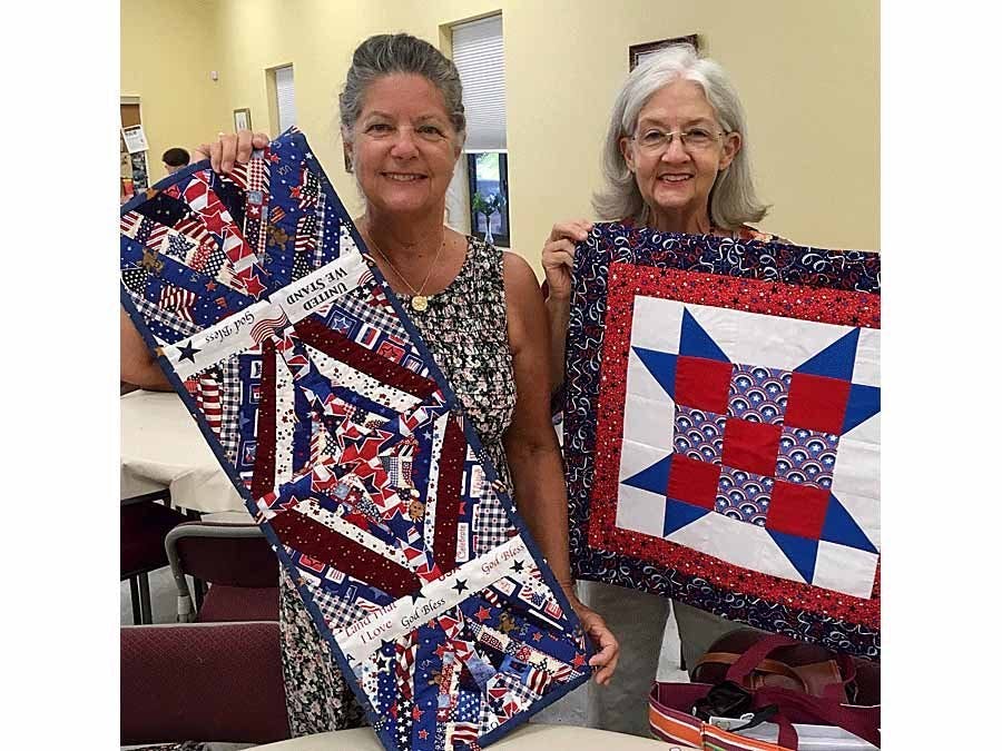 Millie Bernier and Ann Montgomery holding up items made at guild