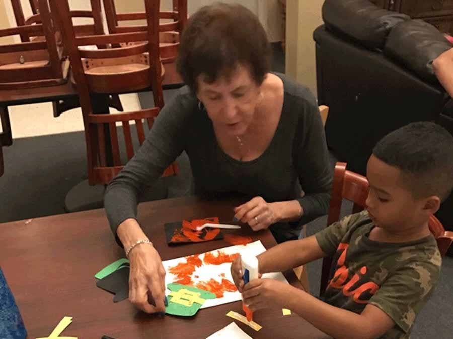 volunteer helping child with artwork