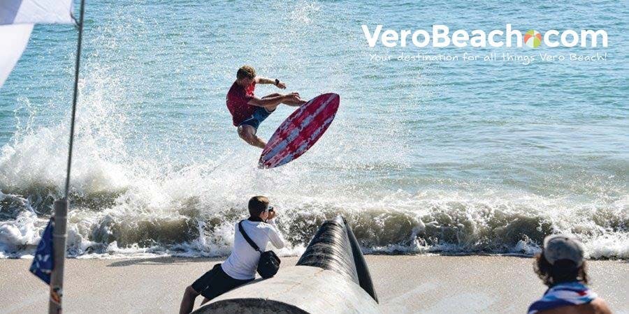 Skim boarder jumping out of water on skimboard on beach at Sexton Plaza in Vero Beach, Florida
